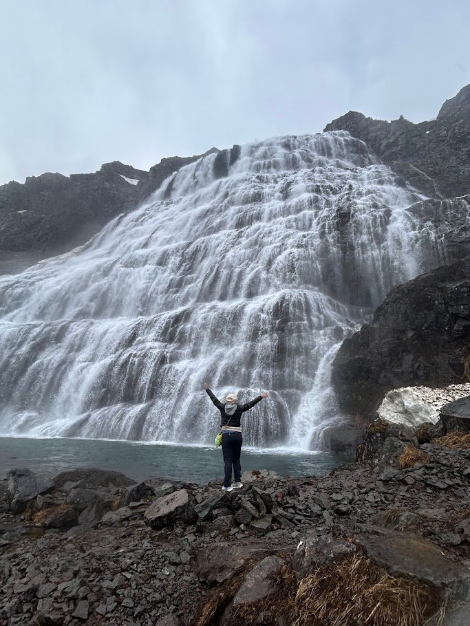 Dynjandi Waterfall with a person standing at the base