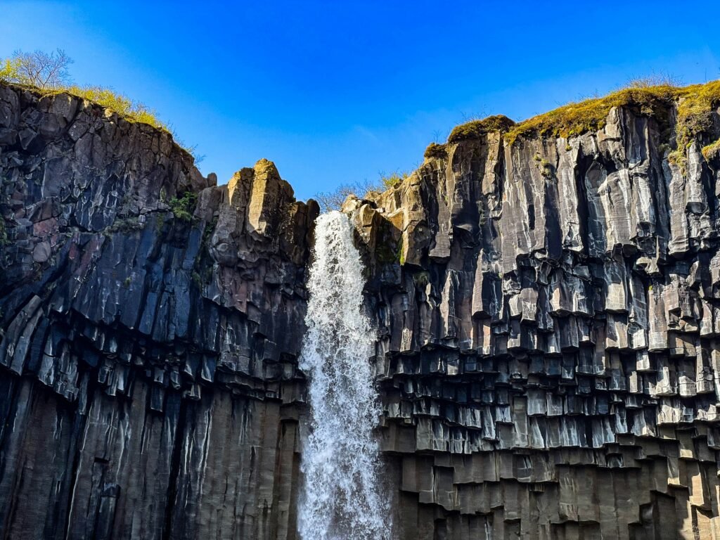 A photo of Svartifoss, a waterfall in Iceland surrounded by hexagonal basalt columns.